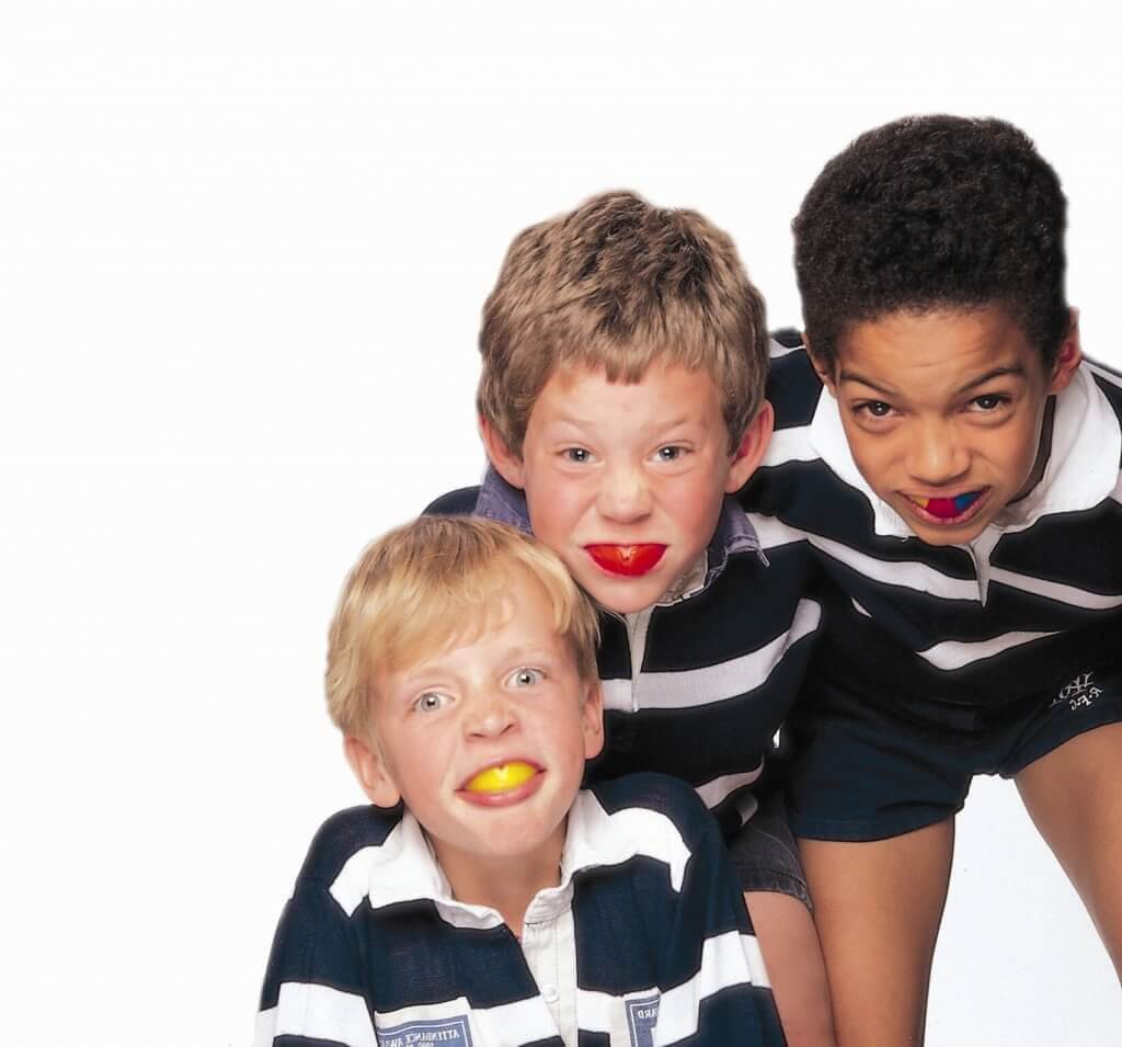 Three kids with navy blue color t-shirt and short paint and mouthguard in the mouth